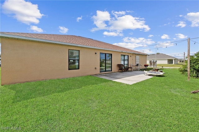 back of house with a patio and a yard