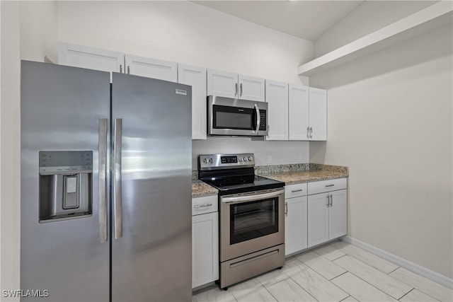 kitchen featuring light stone countertops, white cabinetry, and appliances with stainless steel finishes