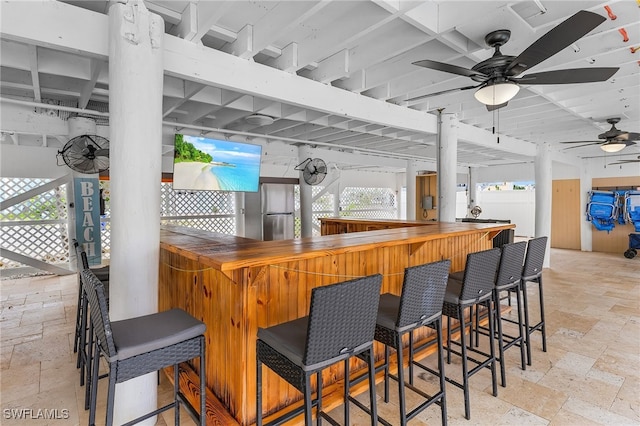 interior space featuring butcher block counters, ceiling fan, and stainless steel fridge