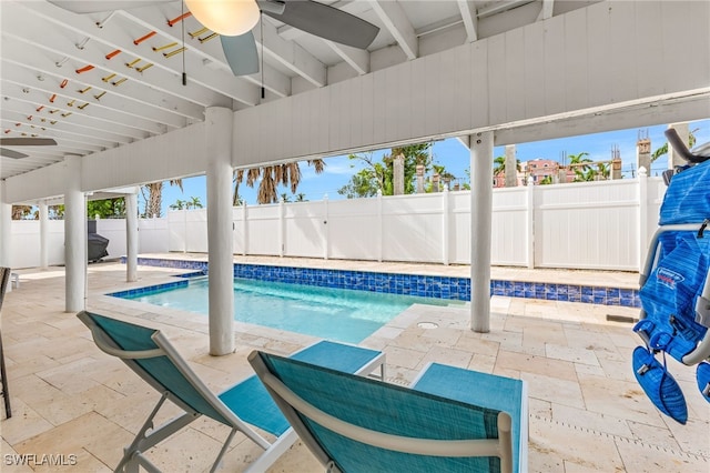 view of swimming pool featuring ceiling fan and a patio