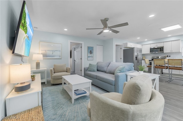 living room with light wood-type flooring and ceiling fan