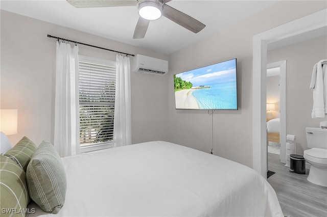 bedroom with an AC wall unit, ceiling fan, and light hardwood / wood-style flooring