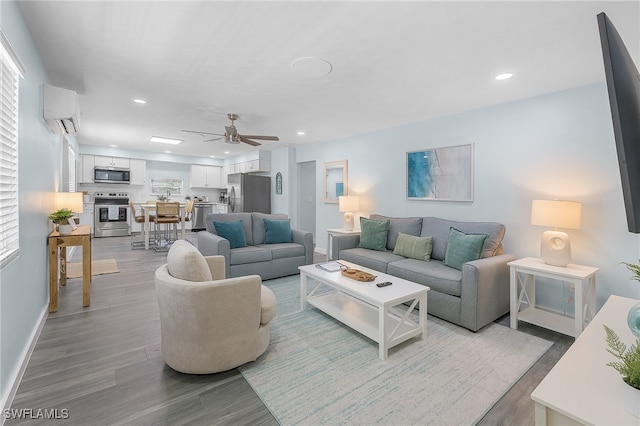 living room with ceiling fan, a wall mounted AC, and light hardwood / wood-style floors