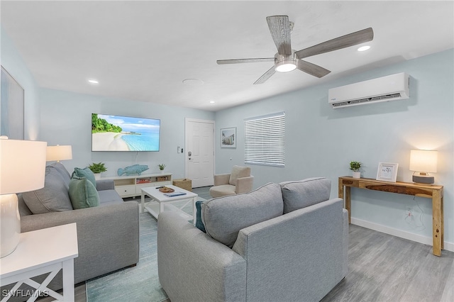 living room featuring ceiling fan, a wall mounted AC, and light hardwood / wood-style flooring