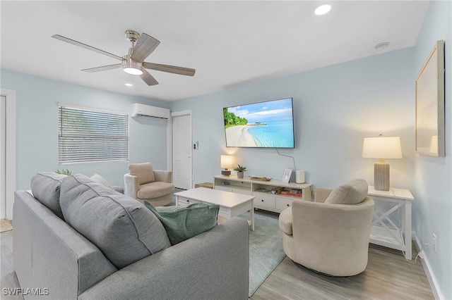 living room featuring ceiling fan, a wall mounted AC, and light hardwood / wood-style flooring