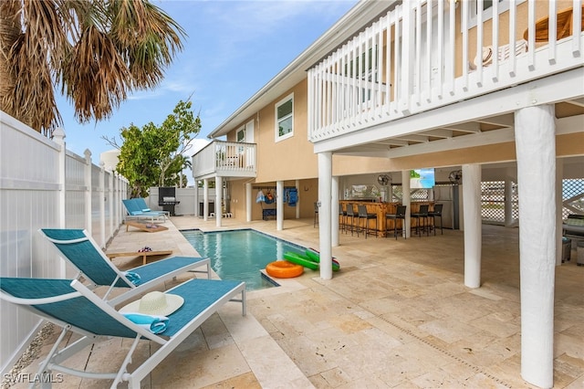 view of swimming pool with an outdoor bar and a patio