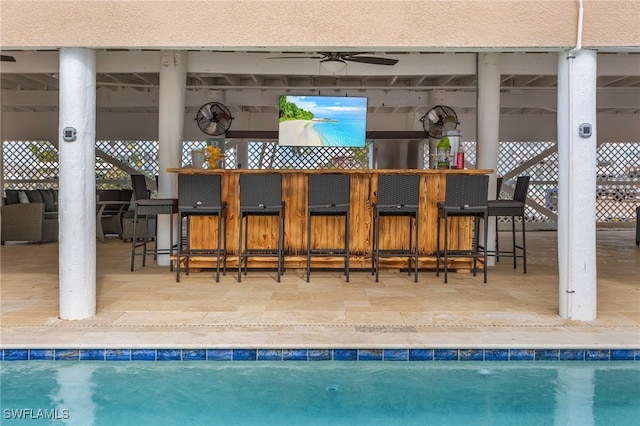 view of pool with a bar, a patio area, and ceiling fan