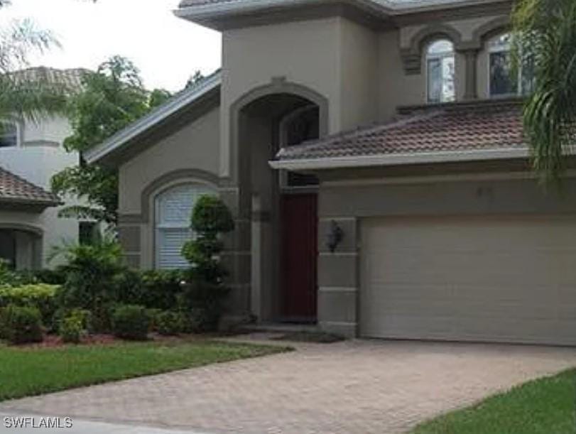 1930 Par Dr, Naples, FL 34120 - mediterranean / spanish home featuring driveway, stucco siding, an attached garage, and a tiled roof
