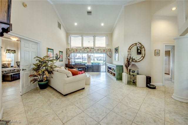 living room with crown molding, light tile patterned floors, and a high ceiling