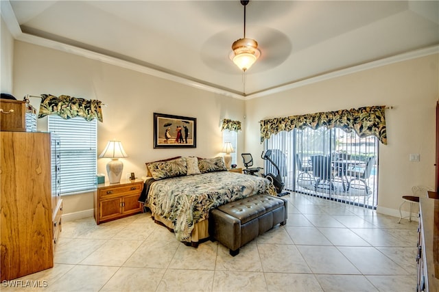 bedroom featuring multiple windows, a raised ceiling, ceiling fan, and access to exterior