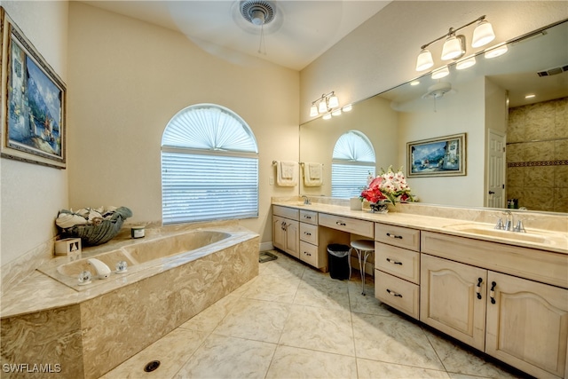 bathroom featuring tiled bath, ceiling fan, and vanity