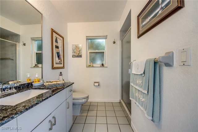 bathroom with toilet, vanity, tile patterned floors, and a shower with shower door