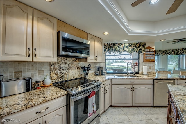 kitchen featuring stainless steel appliances, sink, light stone countertops, light tile patterned floors, and decorative backsplash