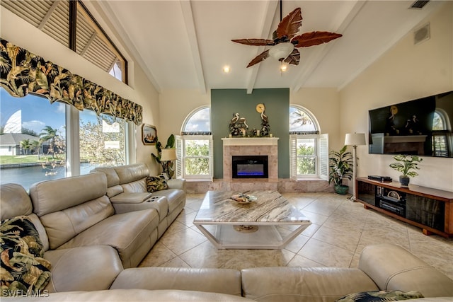 tiled living room featuring a fireplace, ceiling fan, and high vaulted ceiling