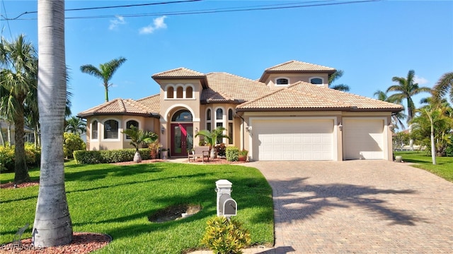 mediterranean / spanish house with a garage and a front yard