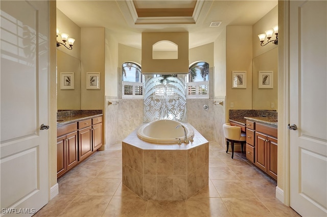 bathroom featuring vanity, a relaxing tiled tub, tile patterned floors, and ornamental molding