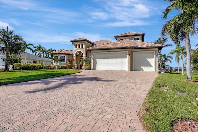 mediterranean / spanish-style house featuring a garage and a front lawn