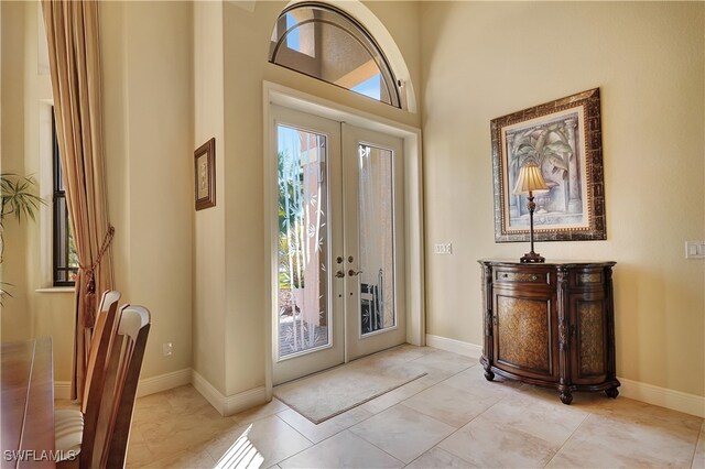 tiled entrance foyer with french doors and a high ceiling