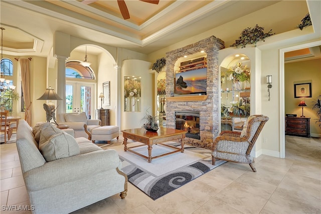 living room featuring french doors, decorative columns, ornamental molding, ceiling fan, and a fireplace