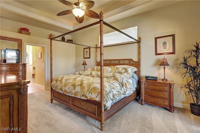 carpeted bedroom featuring multiple windows, a raised ceiling, ensuite bath, and ceiling fan