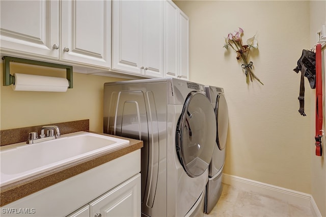 laundry room with light tile patterned flooring, cabinets, sink, and washing machine and clothes dryer