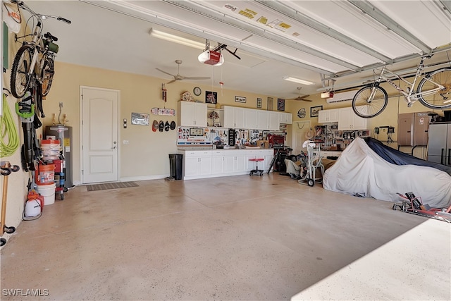 garage featuring a workshop area, a garage door opener, and water heater