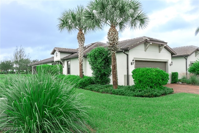 view of side of home featuring a garage and a lawn