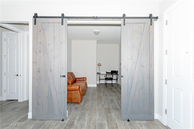living area featuring a barn door and light hardwood / wood-style flooring