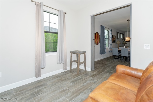 living room featuring wood-type flooring, a healthy amount of sunlight, and a chandelier