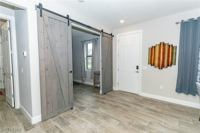 empty room with light wood-type flooring and a barn door