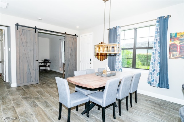 dining area featuring a barn door and hardwood / wood-style flooring