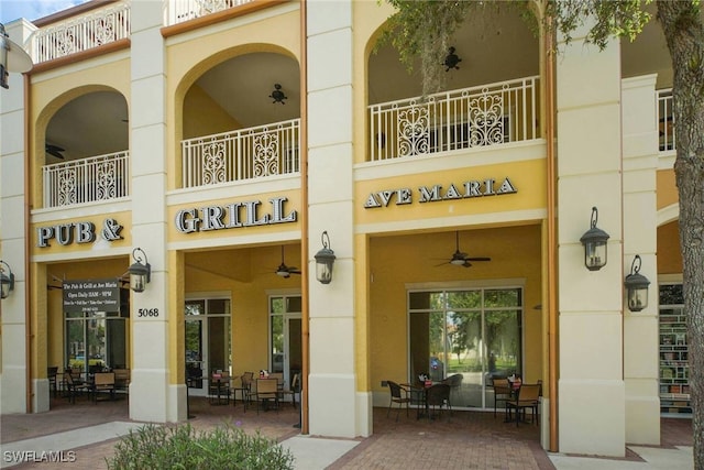 exterior space with ceiling fan and a balcony