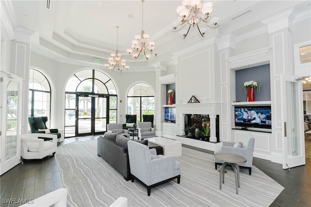 living room with a chandelier, french doors, a fireplace, hardwood / wood-style flooring, and a tray ceiling