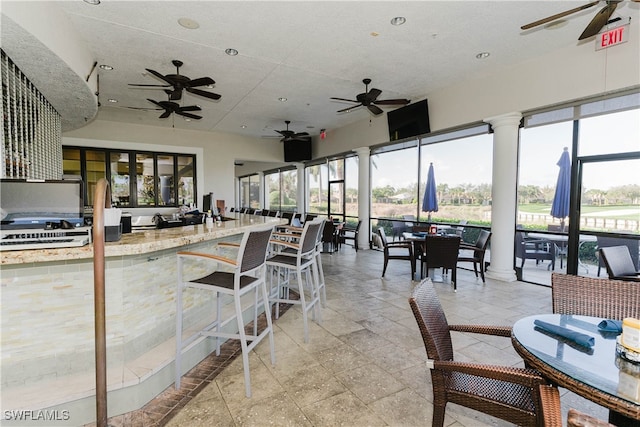 interior space featuring light stone countertops and decorative columns