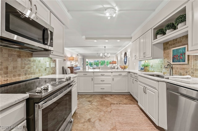 kitchen with sink, stainless steel appliances, ornamental molding, white cabinets, and kitchen peninsula