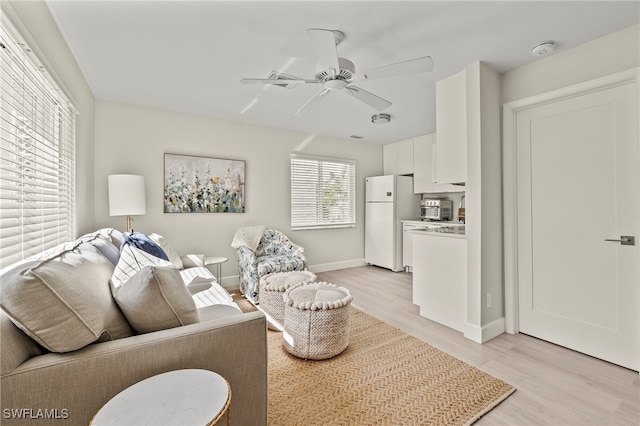 living room with ceiling fan and light hardwood / wood-style floors