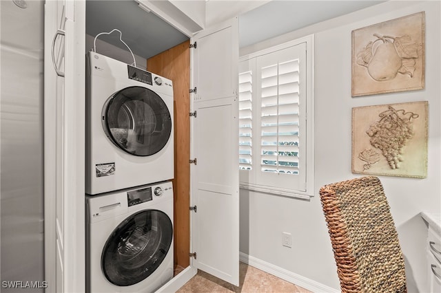 washroom featuring stacked washer and dryer and light tile patterned floors