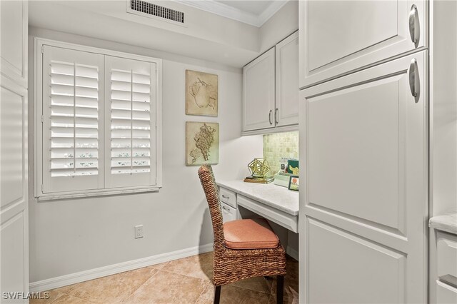 tiled office with crown molding and built in desk