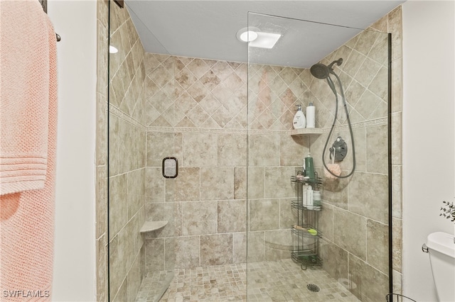 bathroom with a shower with door and toilet