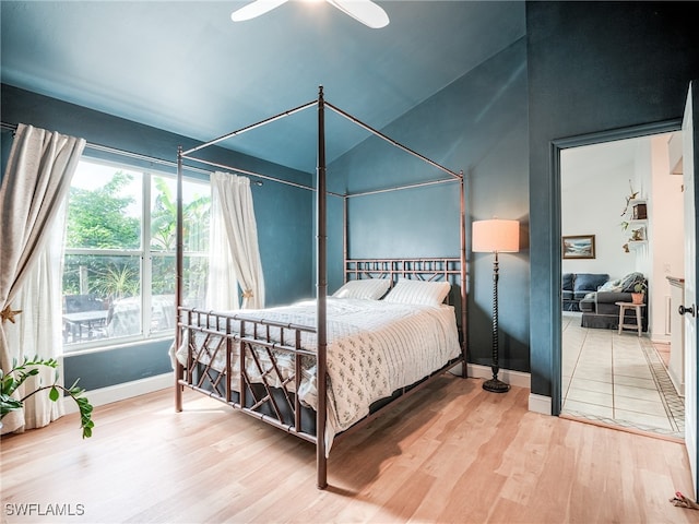 bedroom with ceiling fan, vaulted ceiling, and wood-type flooring