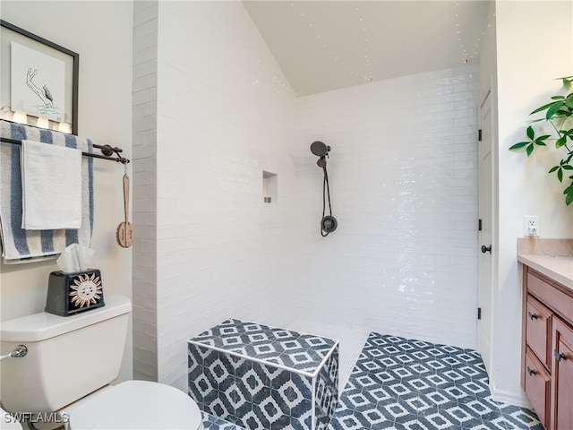 bathroom featuring vanity, toilet, and vaulted ceiling