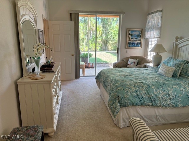 bedroom with access to exterior and light carpet