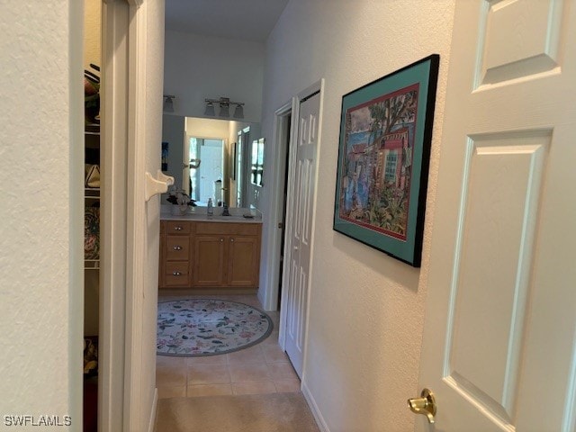 hall featuring sink and light tile patterned floors