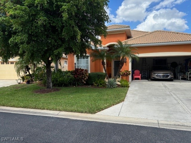 view of front facade with a front yard, a carport, and a garage