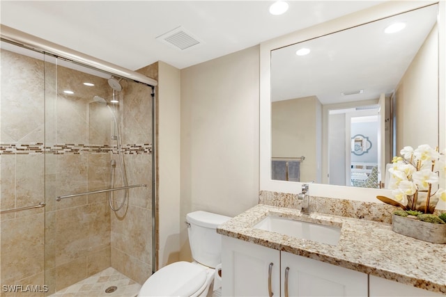 bathroom featuring an enclosed shower, vanity, and toilet