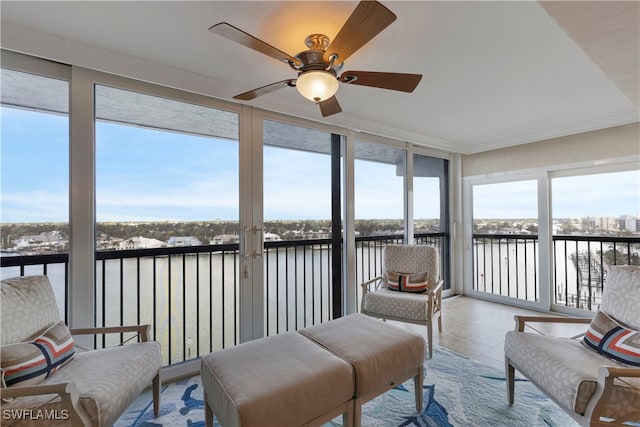 sunroom with a water view and ceiling fan