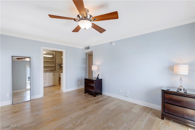 unfurnished bedroom featuring light hardwood / wood-style floors, ceiling fan, crown molding, and connected bathroom