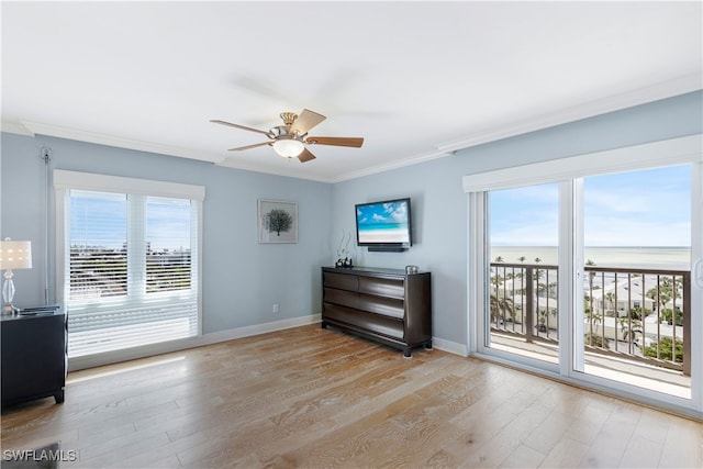 interior space with light wood-type flooring, ceiling fan, and crown molding