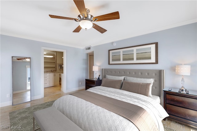 bedroom featuring ceiling fan, ensuite bath, light wood-type flooring, and ornamental molding