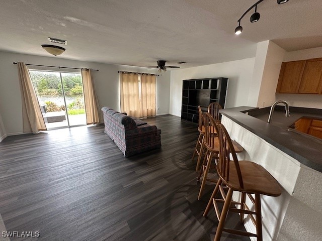 dining area featuring a textured ceiling, dark hardwood / wood-style flooring, and ceiling fan